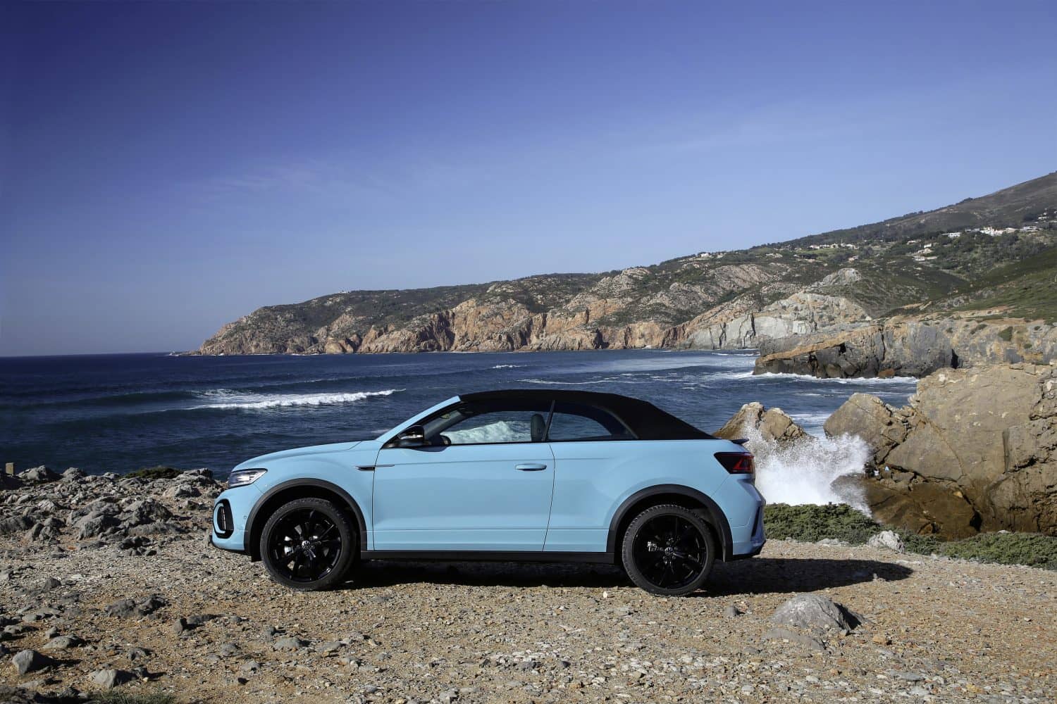 T-Roc Cabrio fotografiado de lado en un entorno natural con techo cerrado.