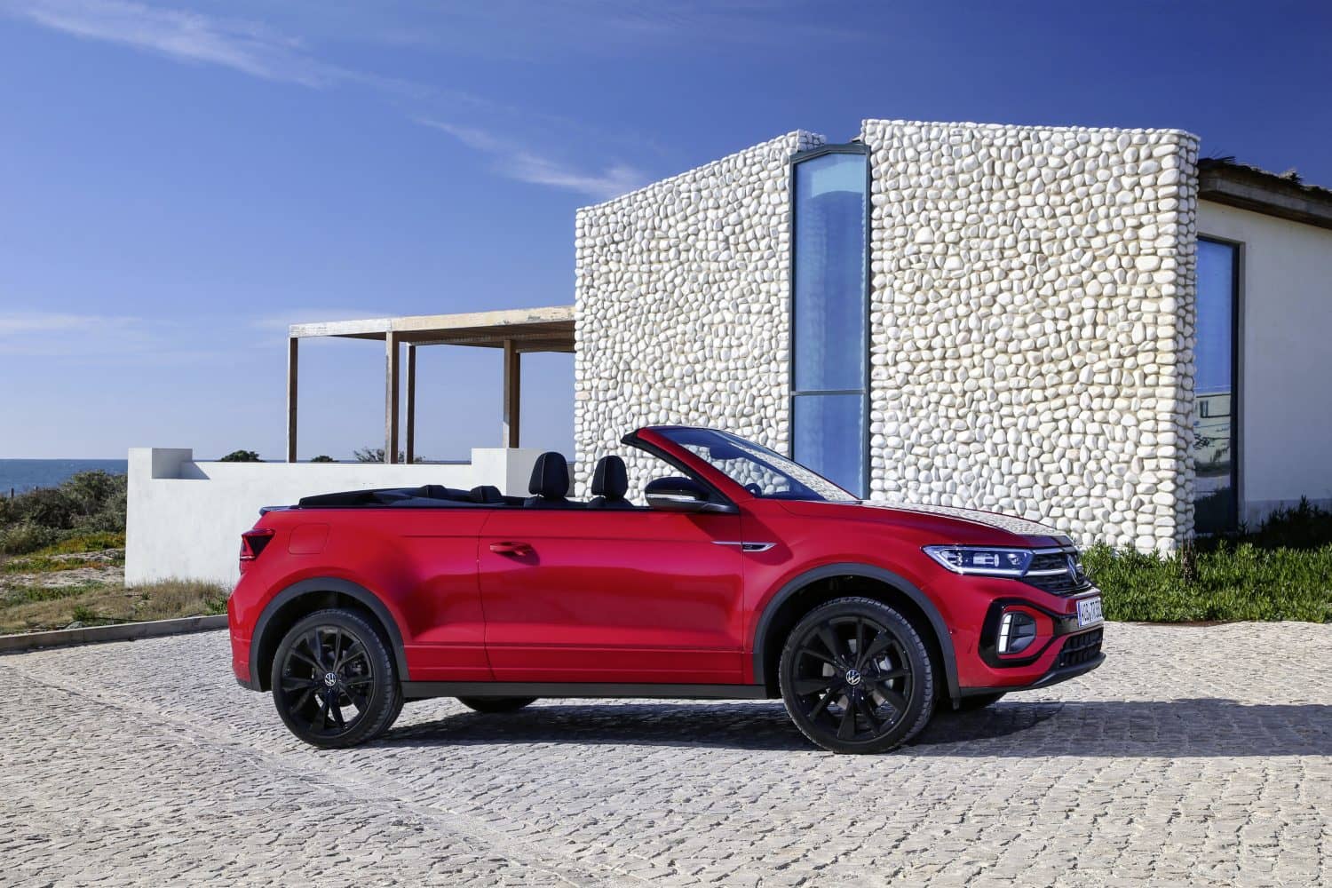 Volkswagen T-Roc Cabrio en rojo, vista lateral con capota baja.