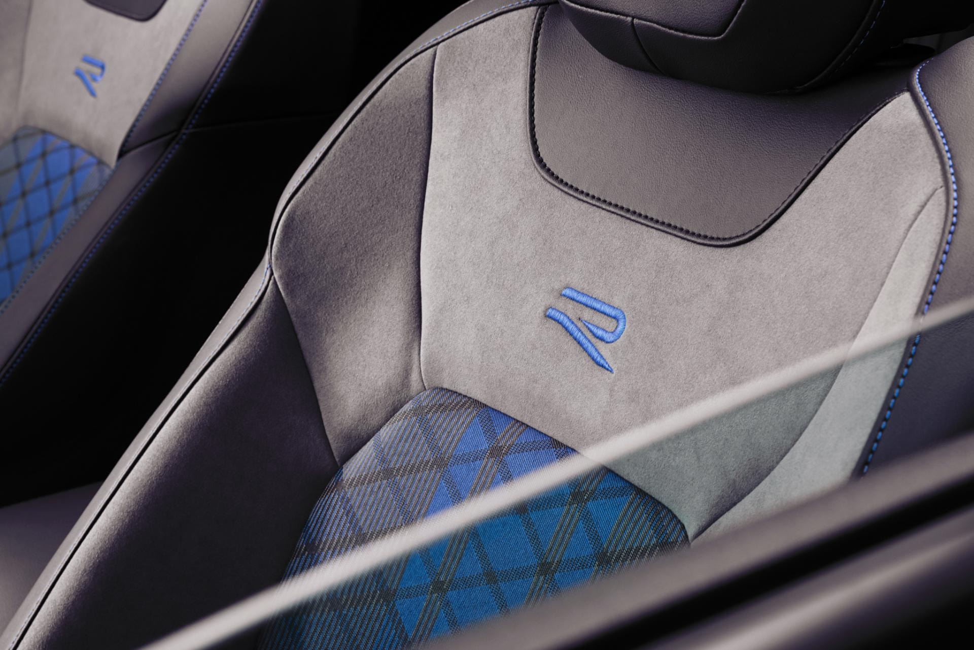 Primer plano del asiento deportivo con logo 'R' y costuras en contraste.
