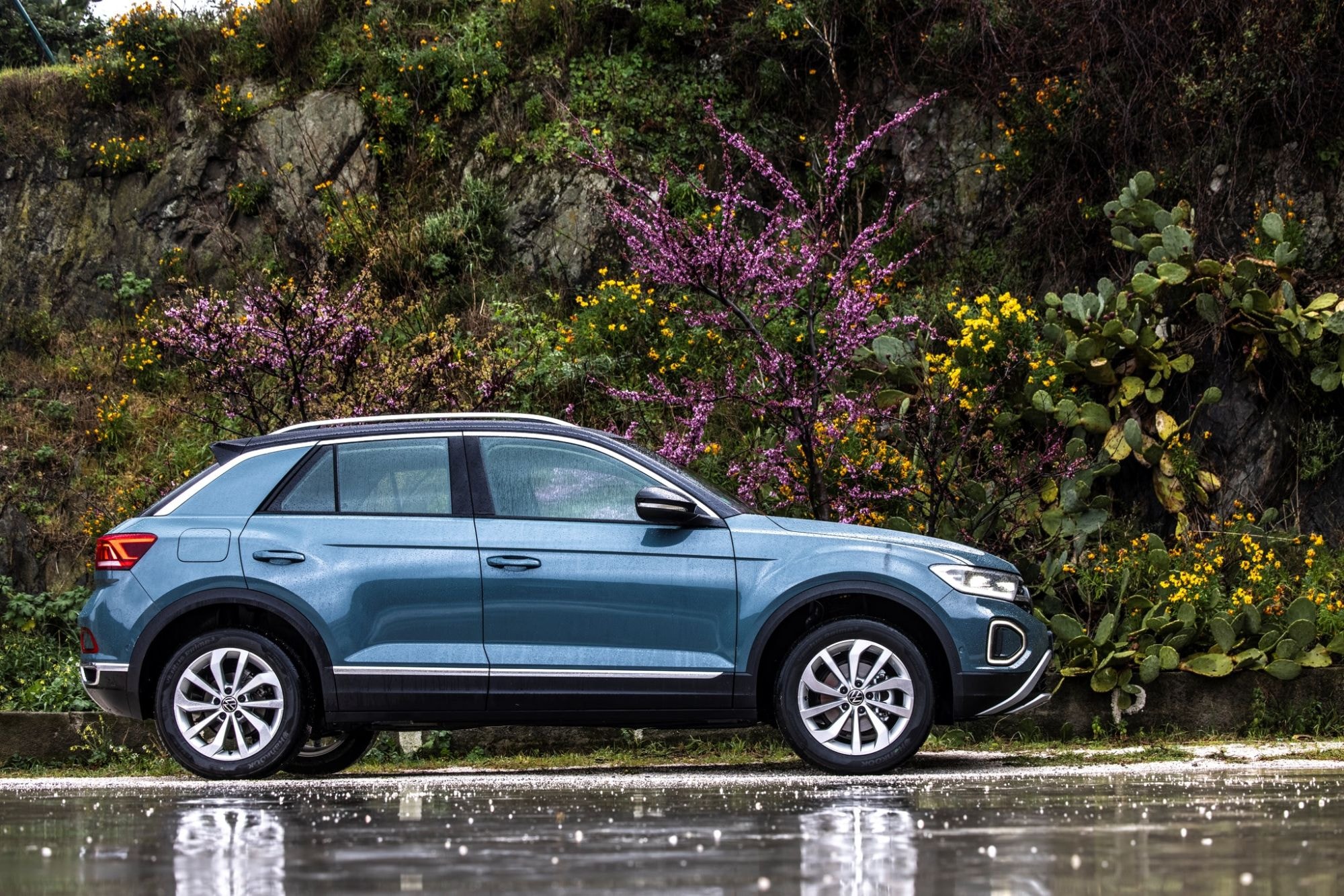 Elegante perfil del Volkswagen T-Roc en un entorno natural con flores.
