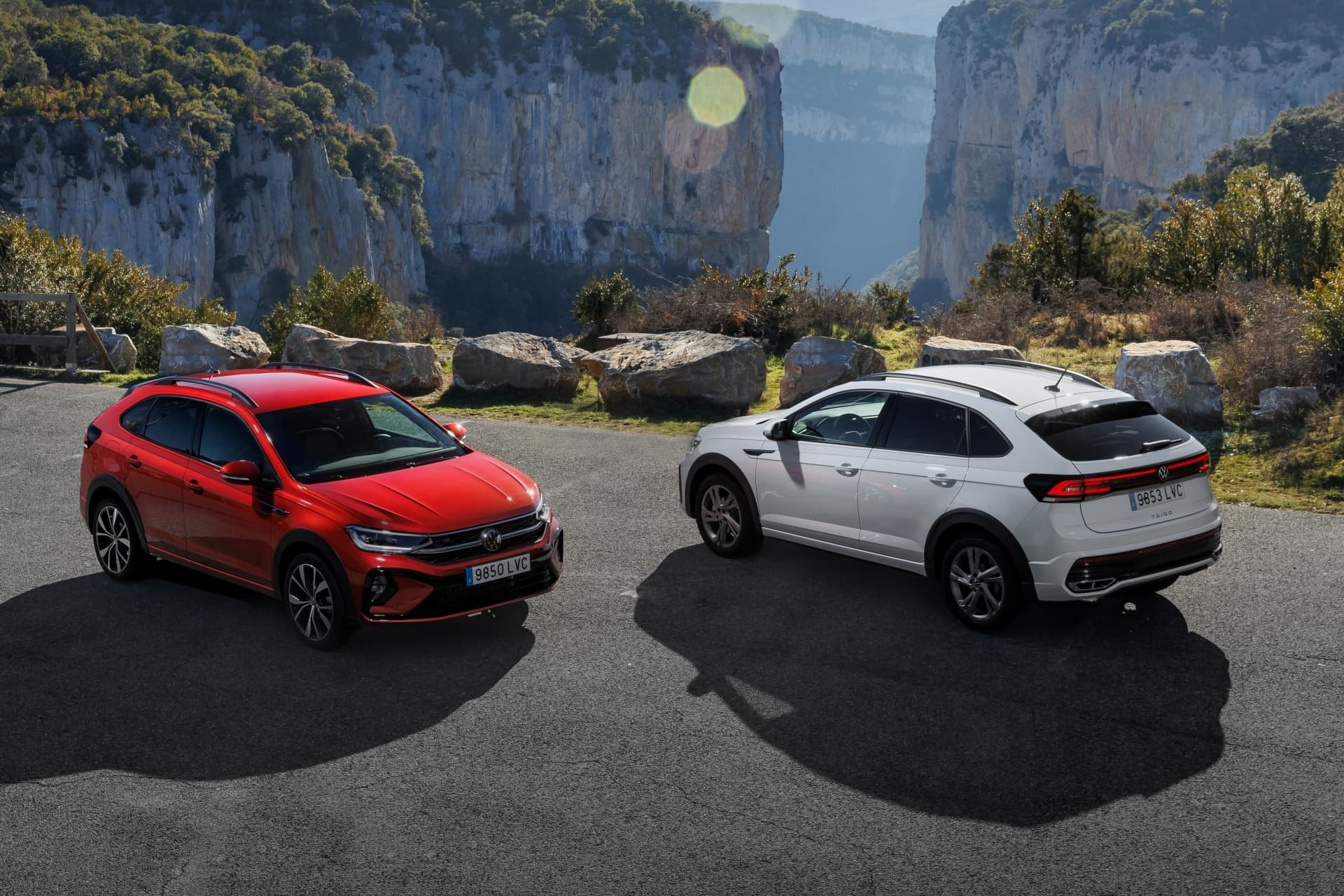 Taigo rojo y blanco aparcados, destacan en paisaje montañoso.