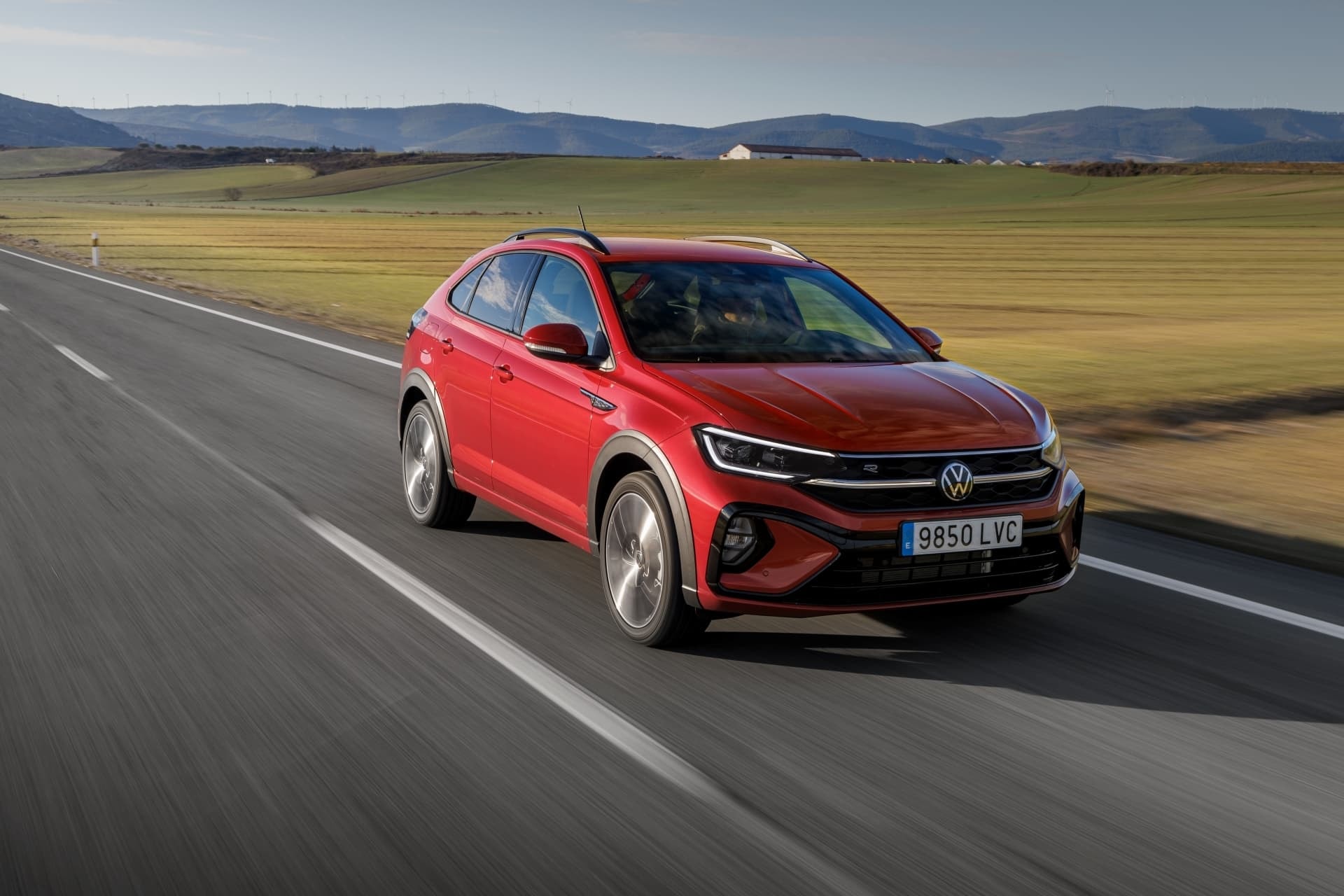 Volkswagen Taigo en color rojo, vista delantera y lateral en movimiento.