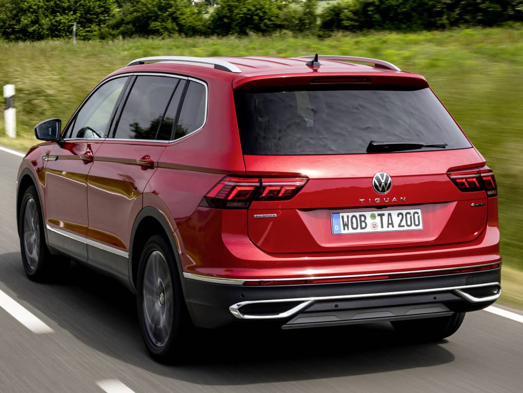 Tiguan Allspace rojo en carretera, mostrando su dinámica trasera lateral.