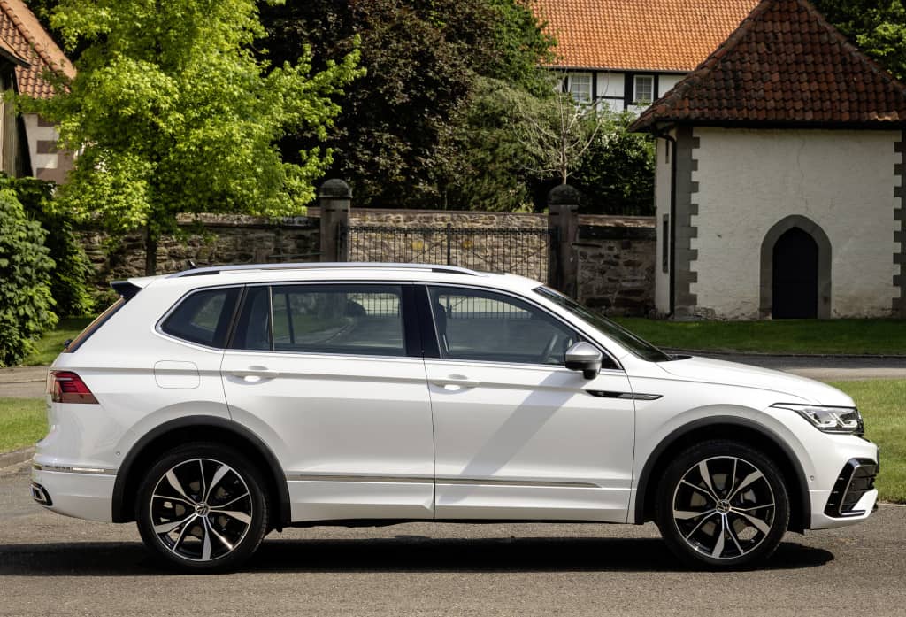 Vista lateral del Volkswagen Tiguan Allspace en color blanco, estacionado.