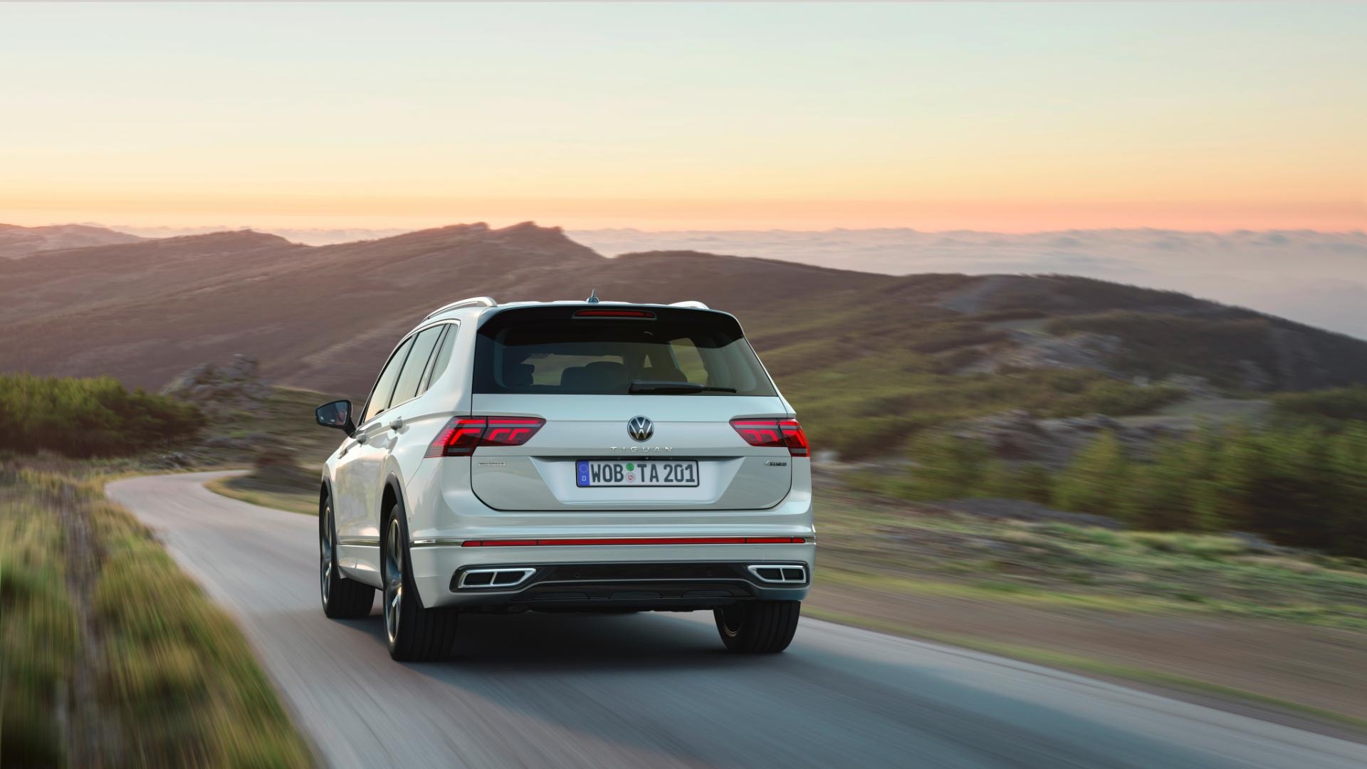 Vista trasera del Tiguan Allspace en carretera al atardecer.