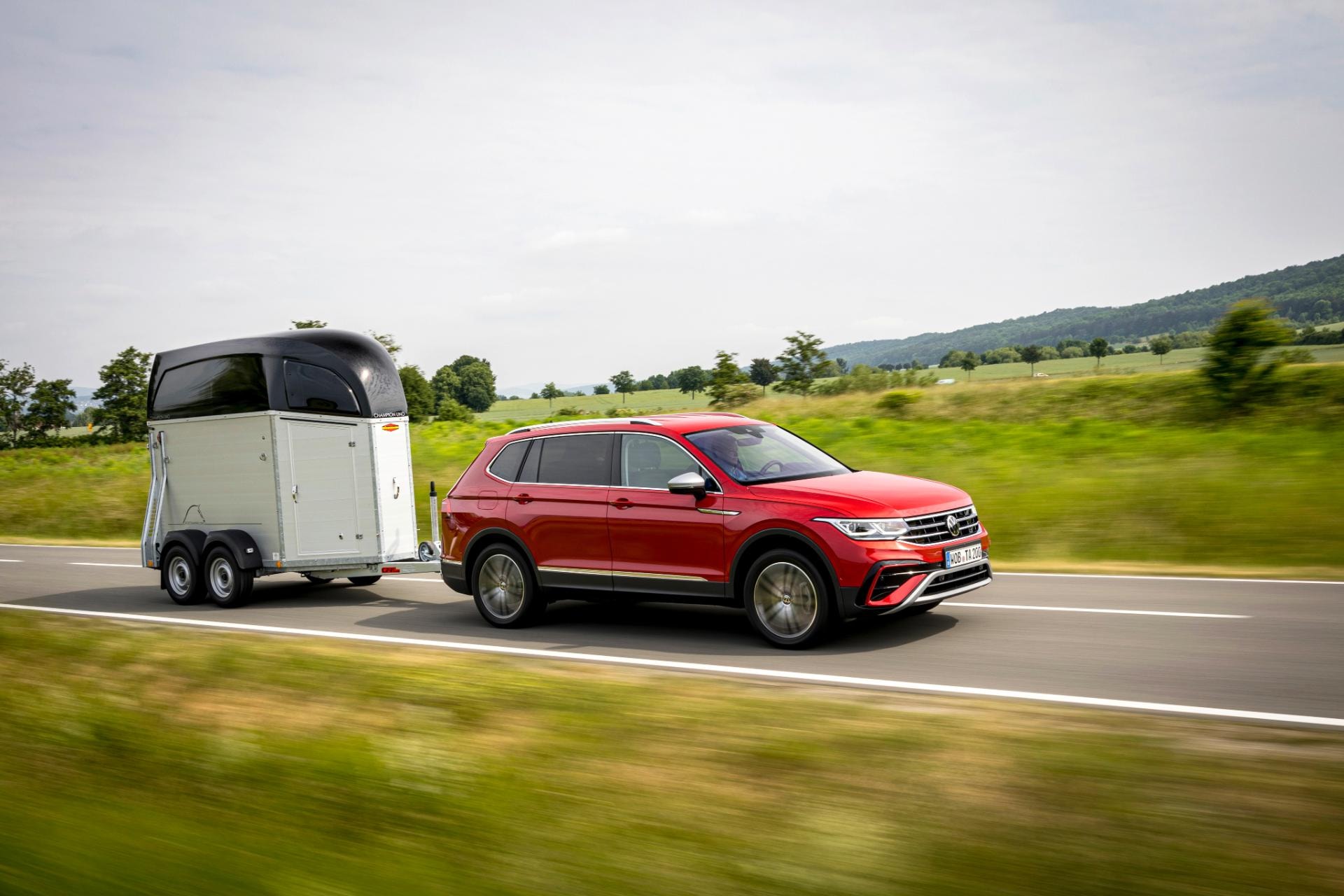 Perfil lateral del Tiguan Allspace en movimiento con remolque, muestra su capacidad de carga.