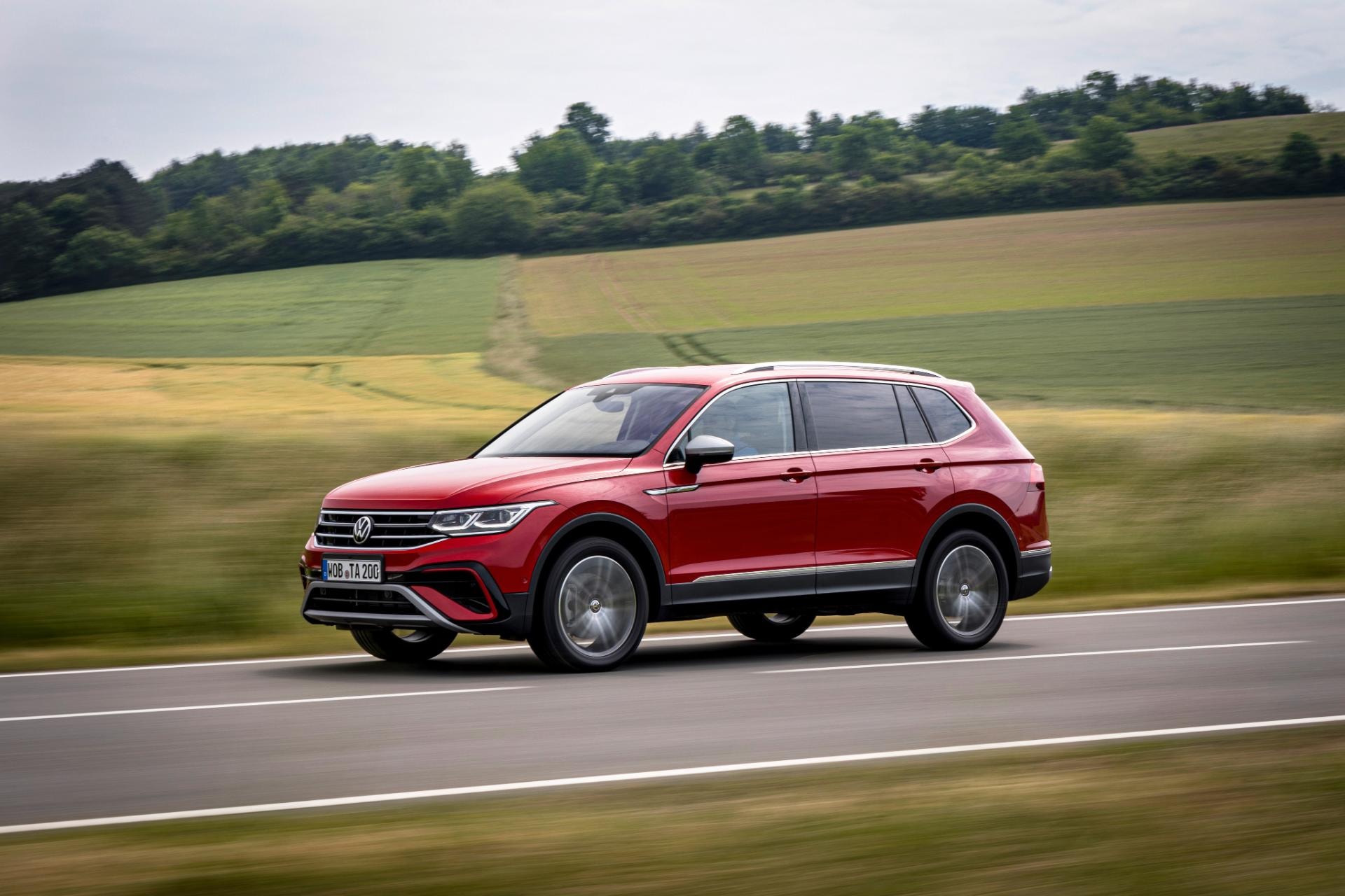 Perfil lateral del Tiguan Allspace en tono rojo, destacando su diseño dinámico.