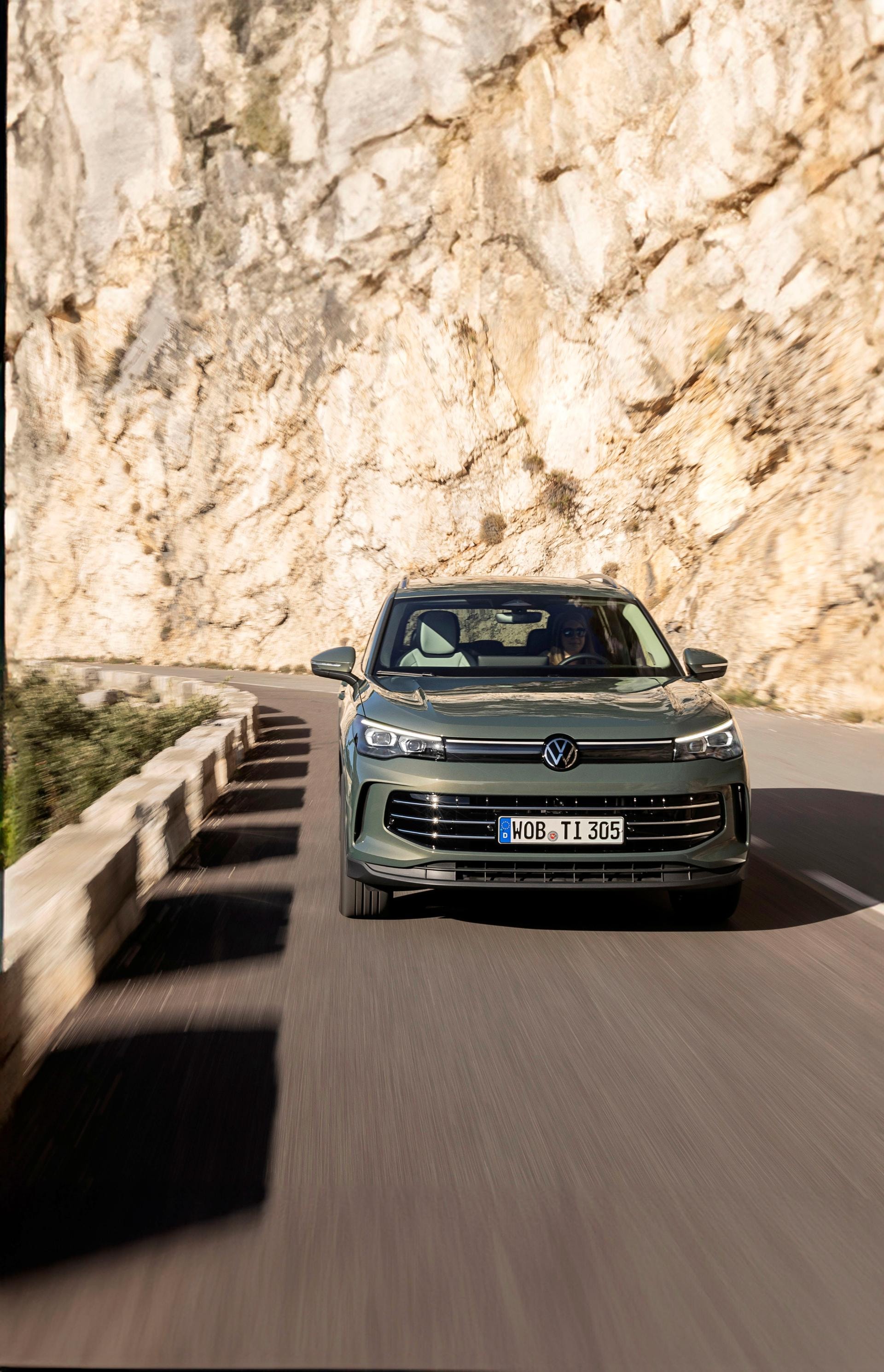 El Tiguan Híbrido se enfrenta a la carretera con el sol de frente, mostrando su frontal.