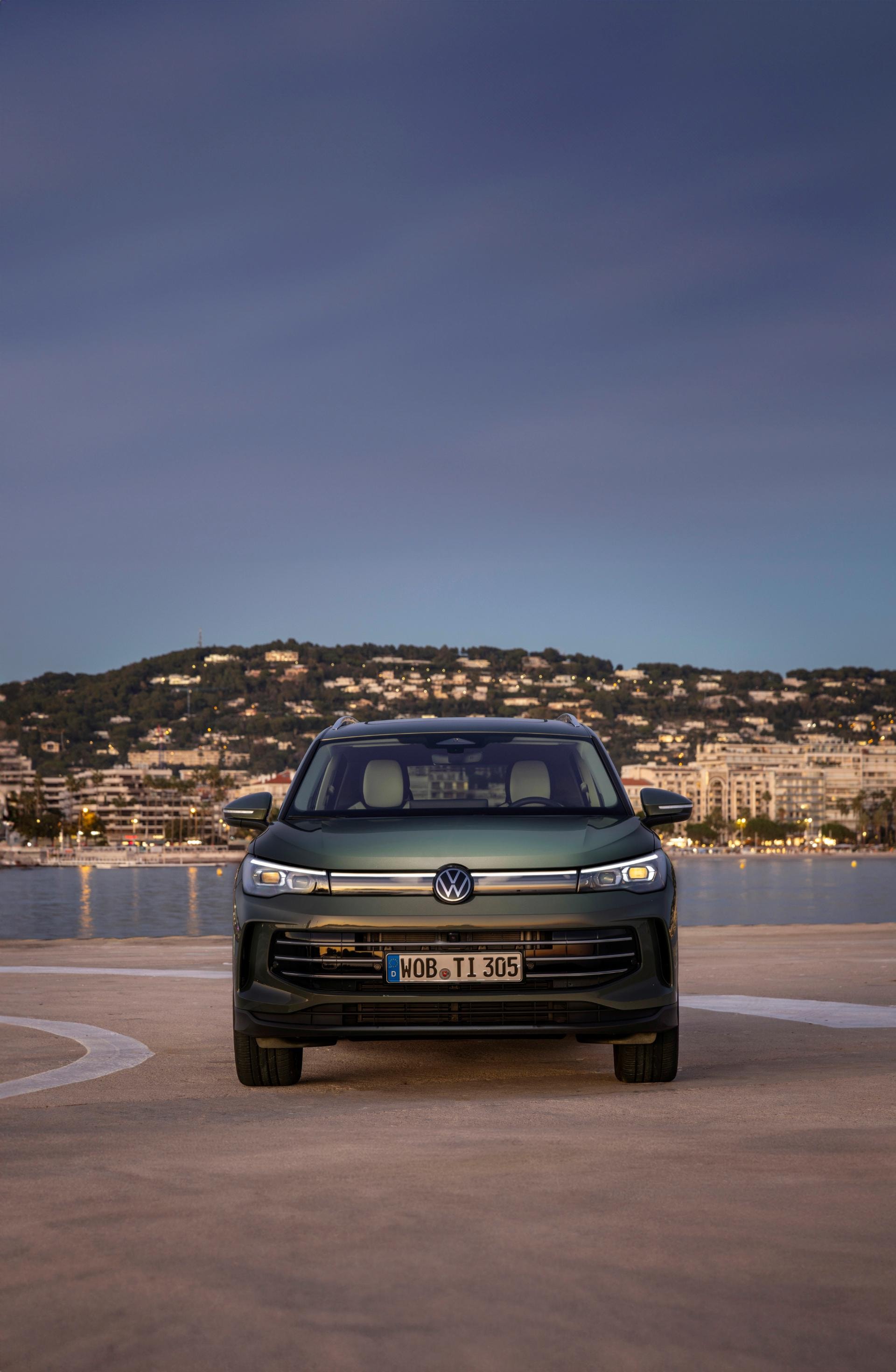 Vista frontal del Tiguan híbrido, resaltando su diseño imponente bajo las luces nocturnas.