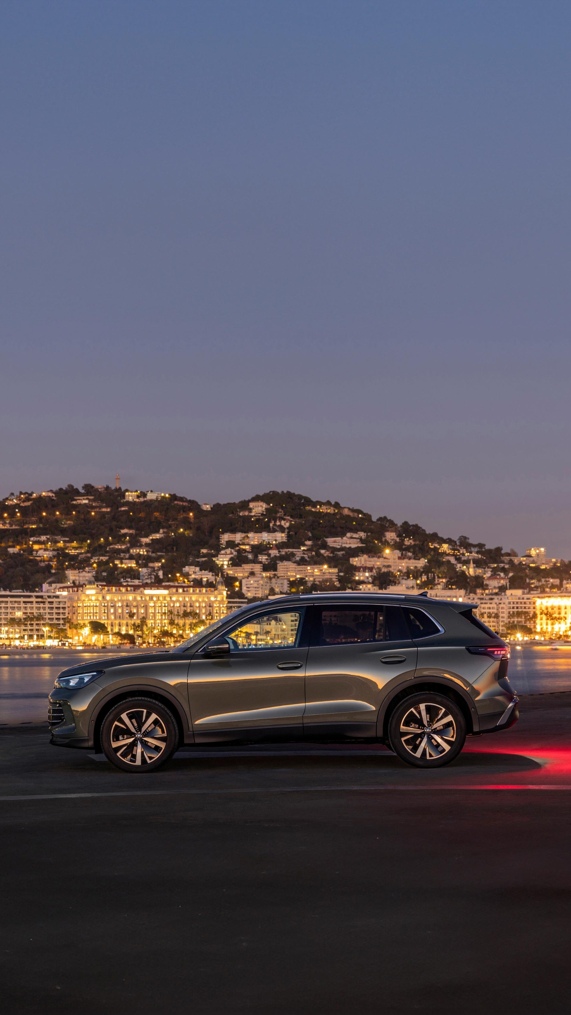 Volkswagen Tiguan híbrido lateral con vista del techo, capturado bajo el cielo nocturno.