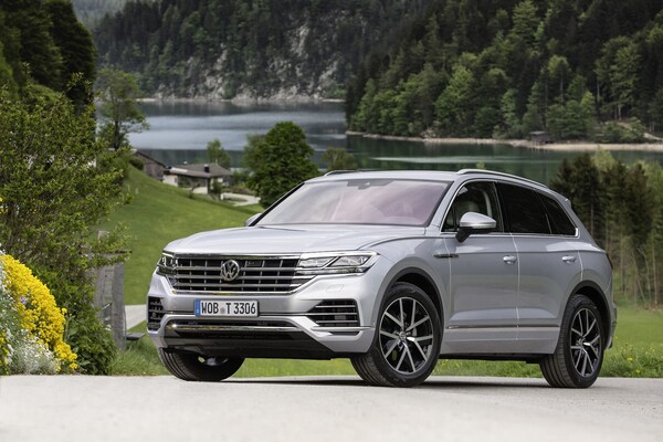 Perfil de Volkswagen Touareg con lago y montañas de fondo, destacando su diseño. Perfil de Volkswagen Touareg con lago y montañas de fondo, destacando su diseño.