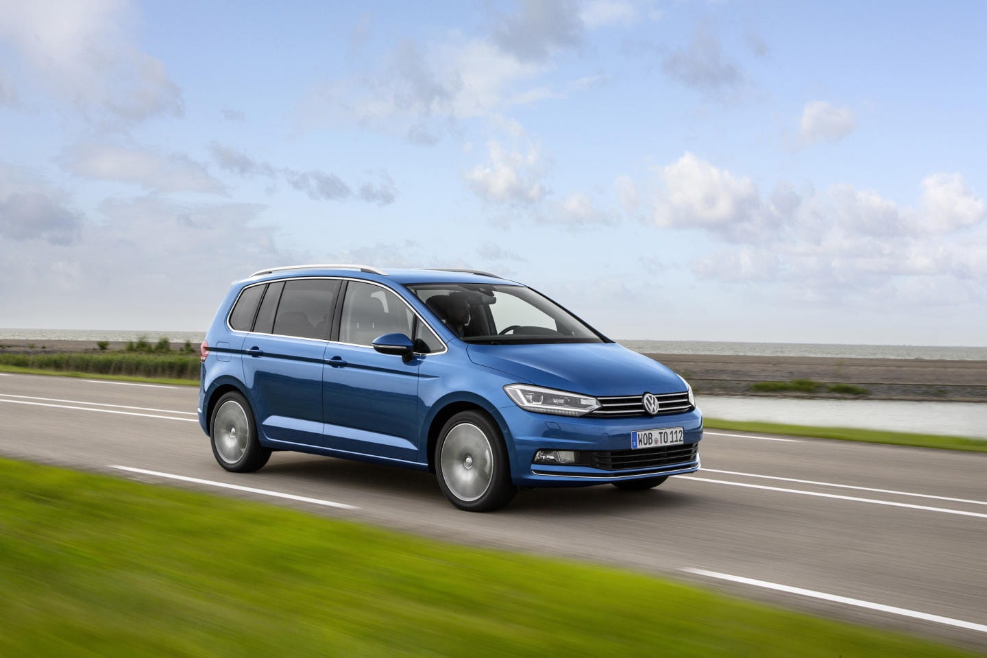 Imagen del Volkswagen Touran en perfil, destacando su diseño en carretera.