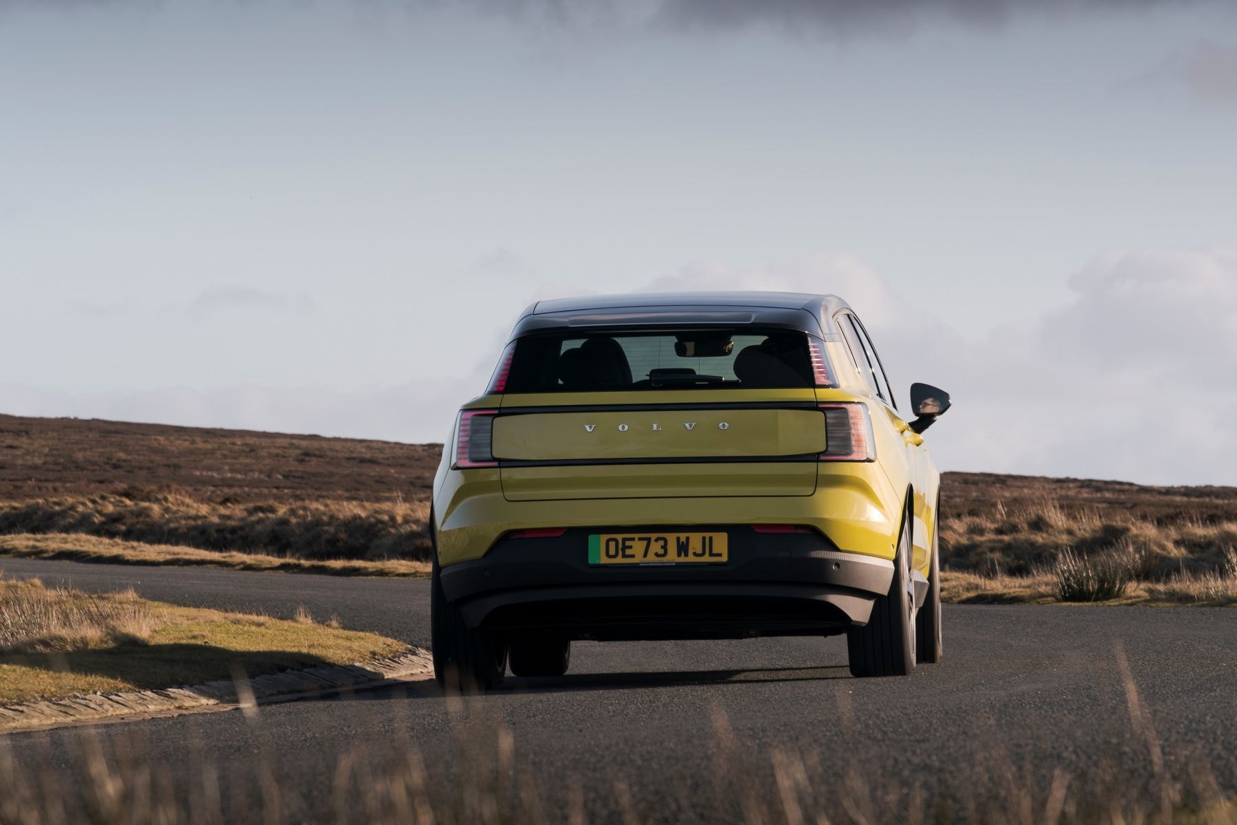 Vista posterior del Volvo EX30 en carretera, mostrando su diseño.