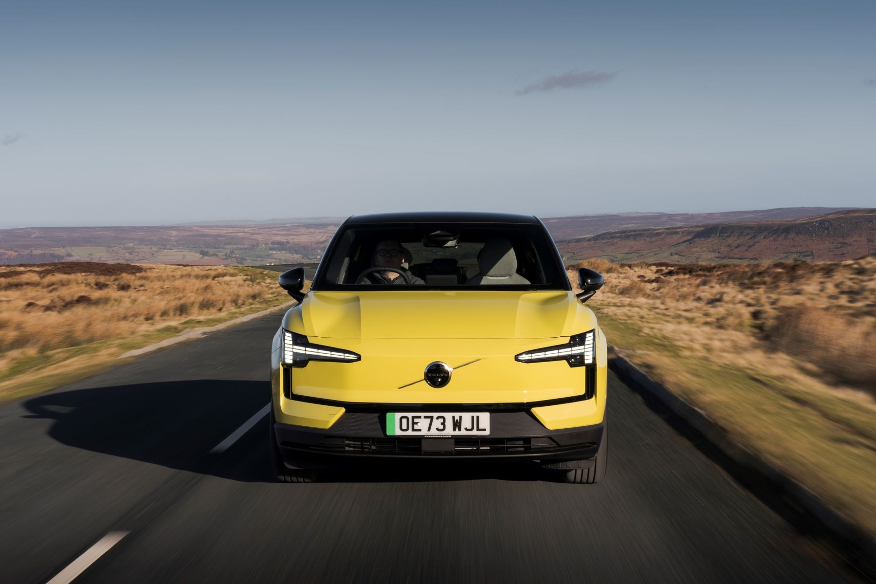 Vista trasera del Volvo EX30 con un atardecer impresionate.