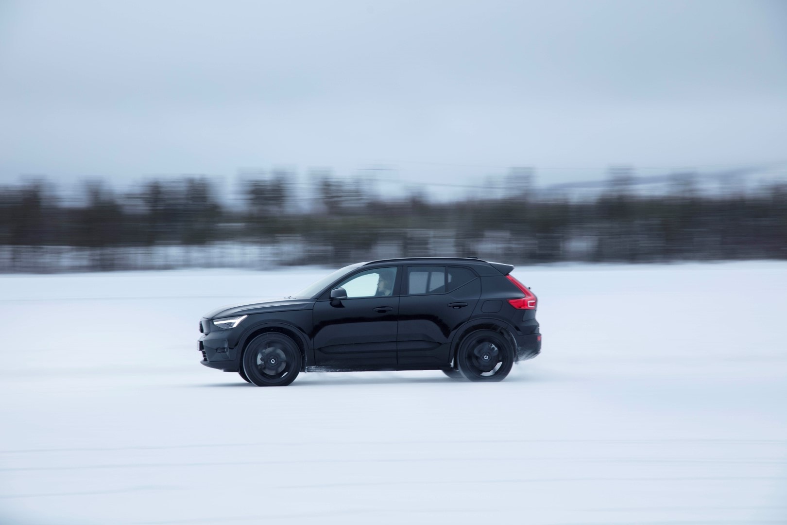 Perfil dinámico del Volvo EX40 eléctrico en movimiento sobre nieve