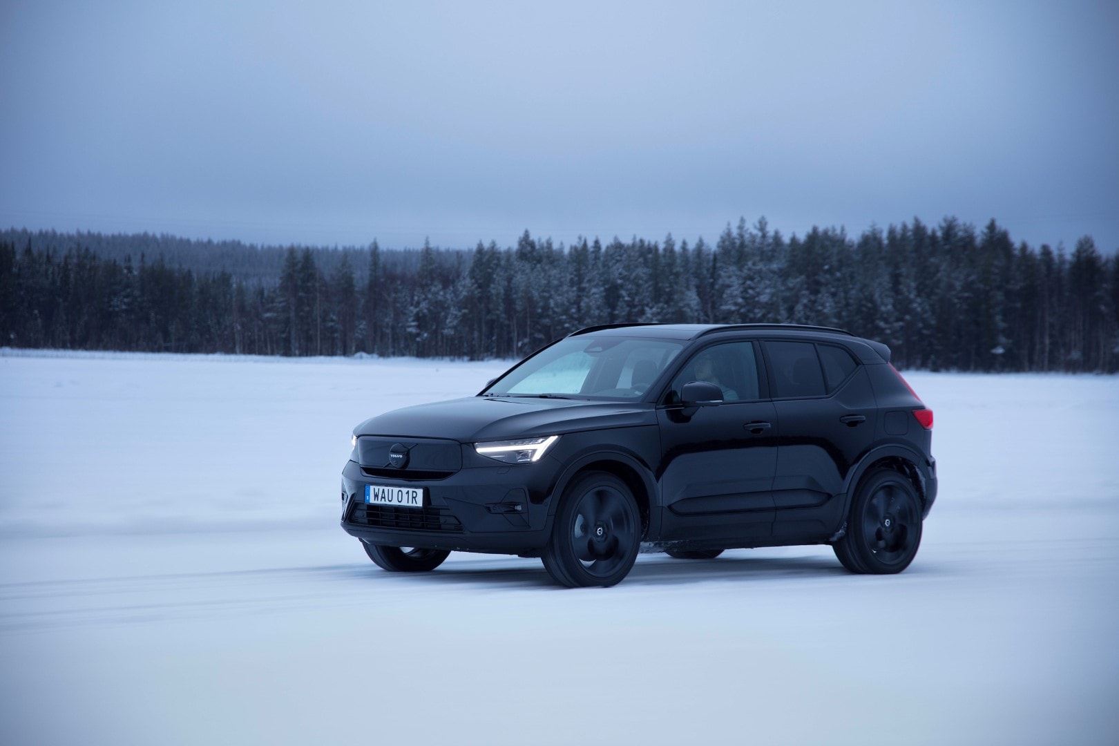 Volvo EX40 eléctrico estático en un entorno nevado, vista lateral