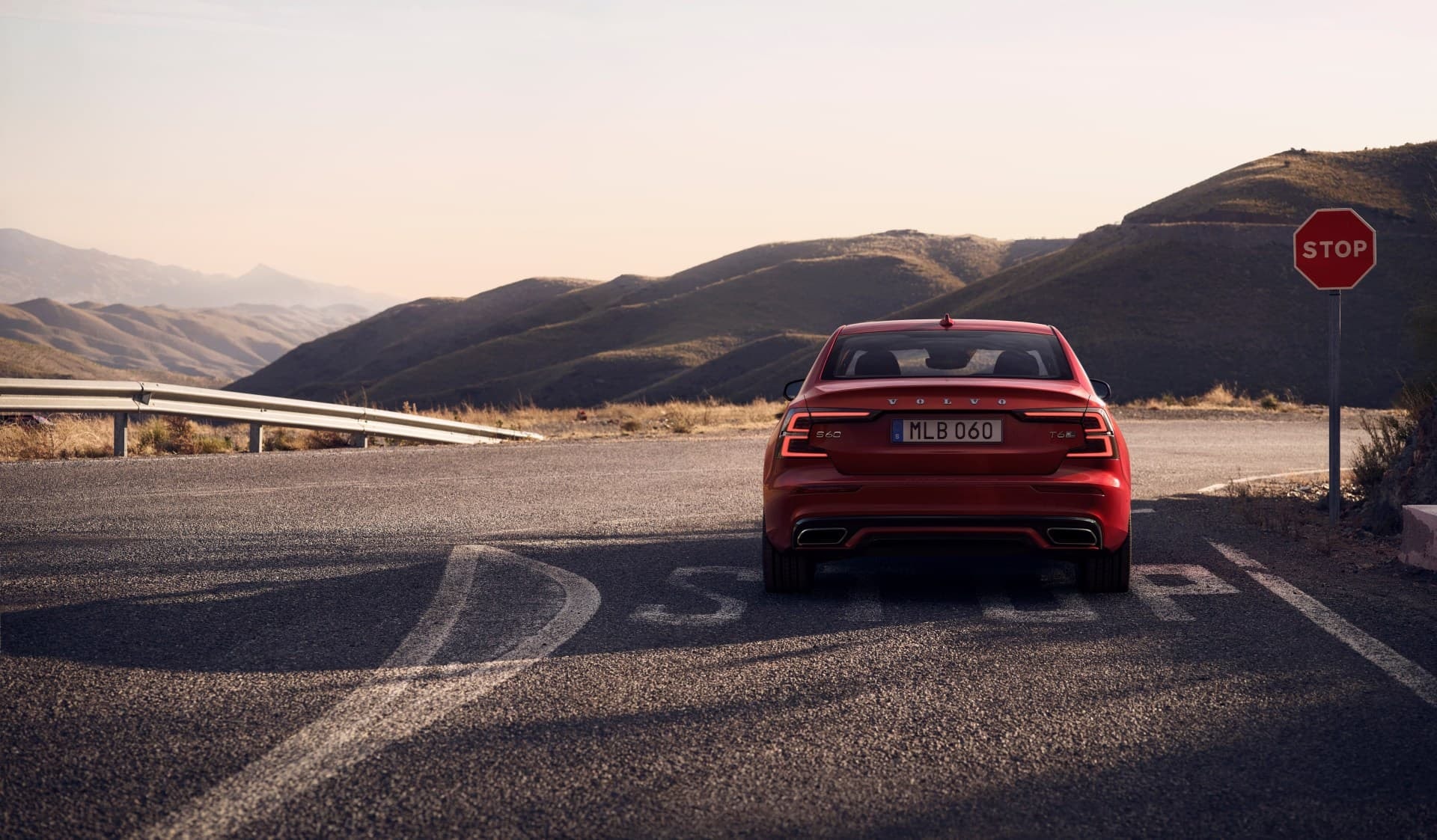 Vista trasera del Volvo S60 mostrando las luces y diseño en un entorno de carretera.