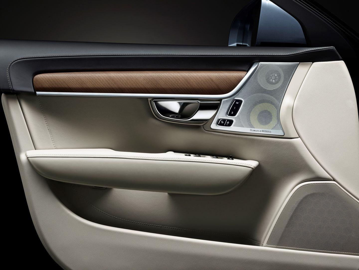 Detalle de la puerta con acabados de madera y altavoces de alta calidad.