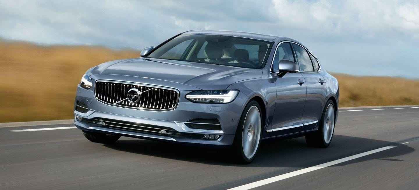 Perspectiva frontal del Volvo S90, resaltando su parrilla distintiva y diseño moderno.