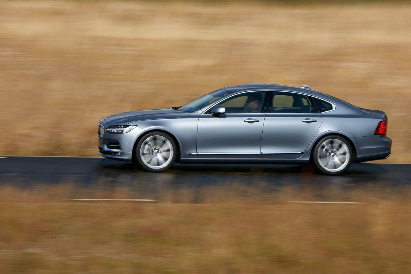 Imagen del Volvo S90 en acción, destacando su línea lateral y estilo.