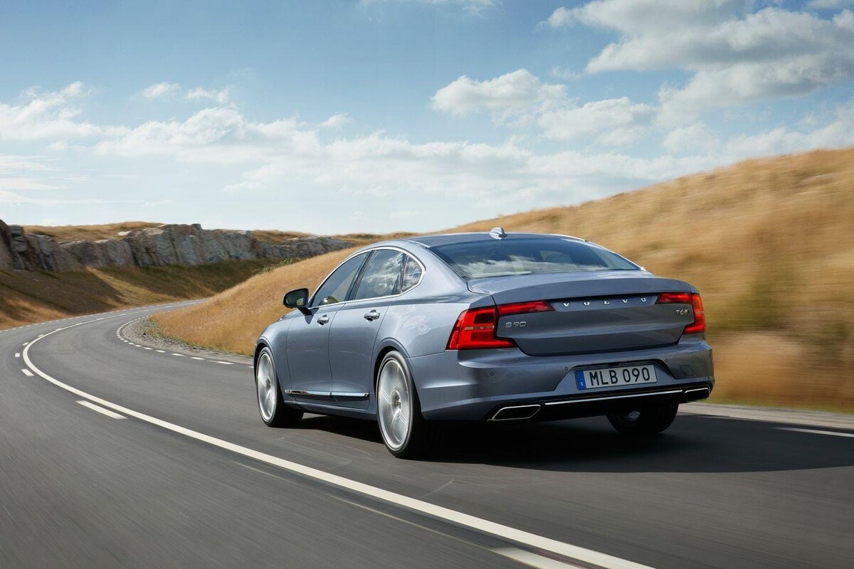 Volvo S90 capturado en movimiento, mostrando su línea lateral y parte trasera. Volvo S90 capturado en movimiento, mostrando su línea lateral y parte trasera.