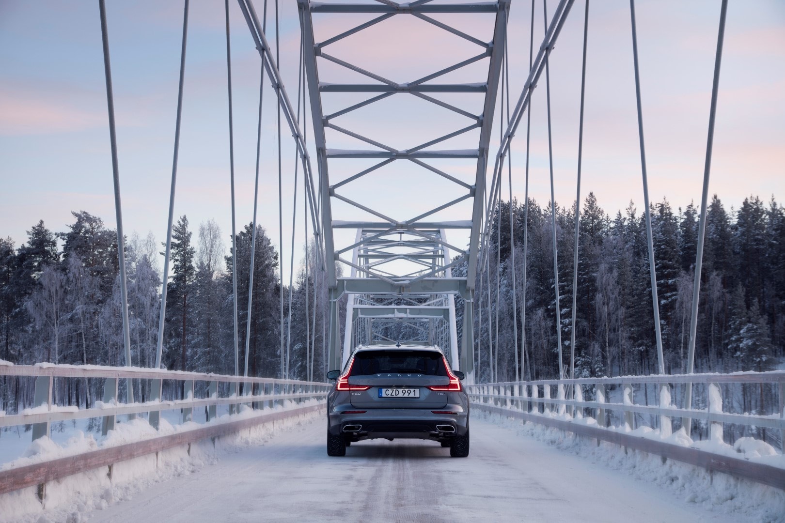 Trasera del Volvo V60 Cross Country cruzando un puente nevado.