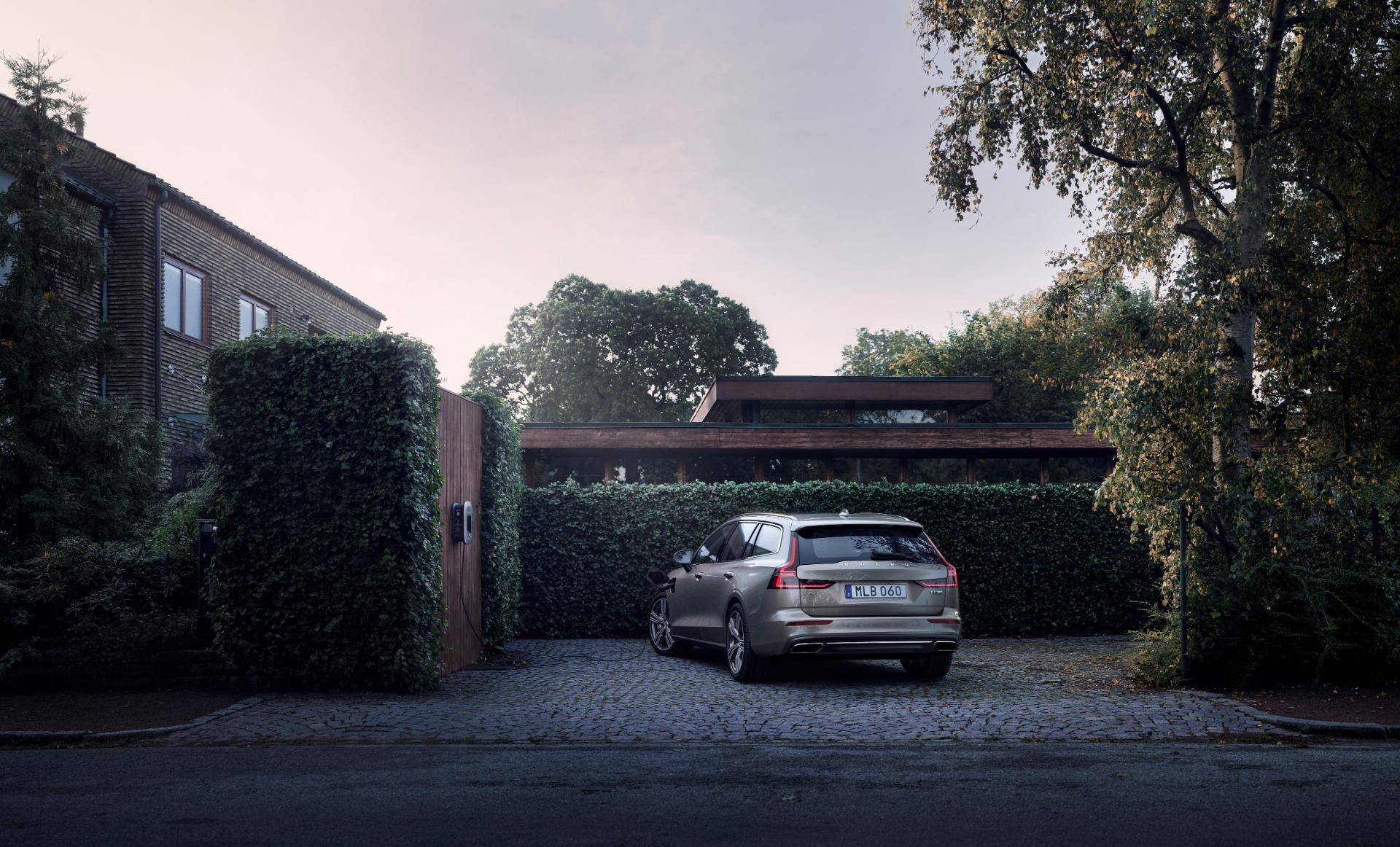 Vista trasera del Volvo V60 Híbrido aparcado en residencia privada.