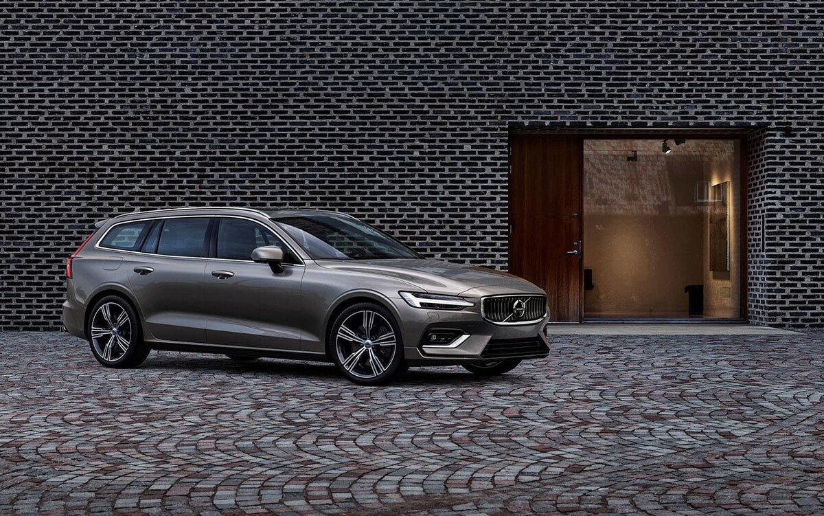 Volvo V60 perfilado ante una fachada moderna, combinación de estilo y tecnología. Volvo V60 perfilado ante una fachada moderna, combinación de estilo y tecnología.