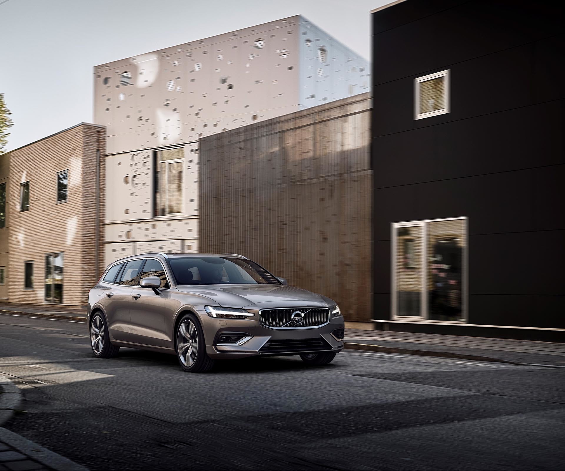 Volvo V60 en entorno urbano, perspectiva frontal y lateral, destaca diseño moderno.