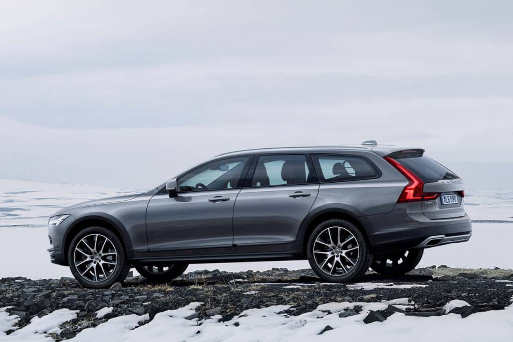 Perfil lateral del Volvo V90 Cross Country sobre un fondo rocoso.