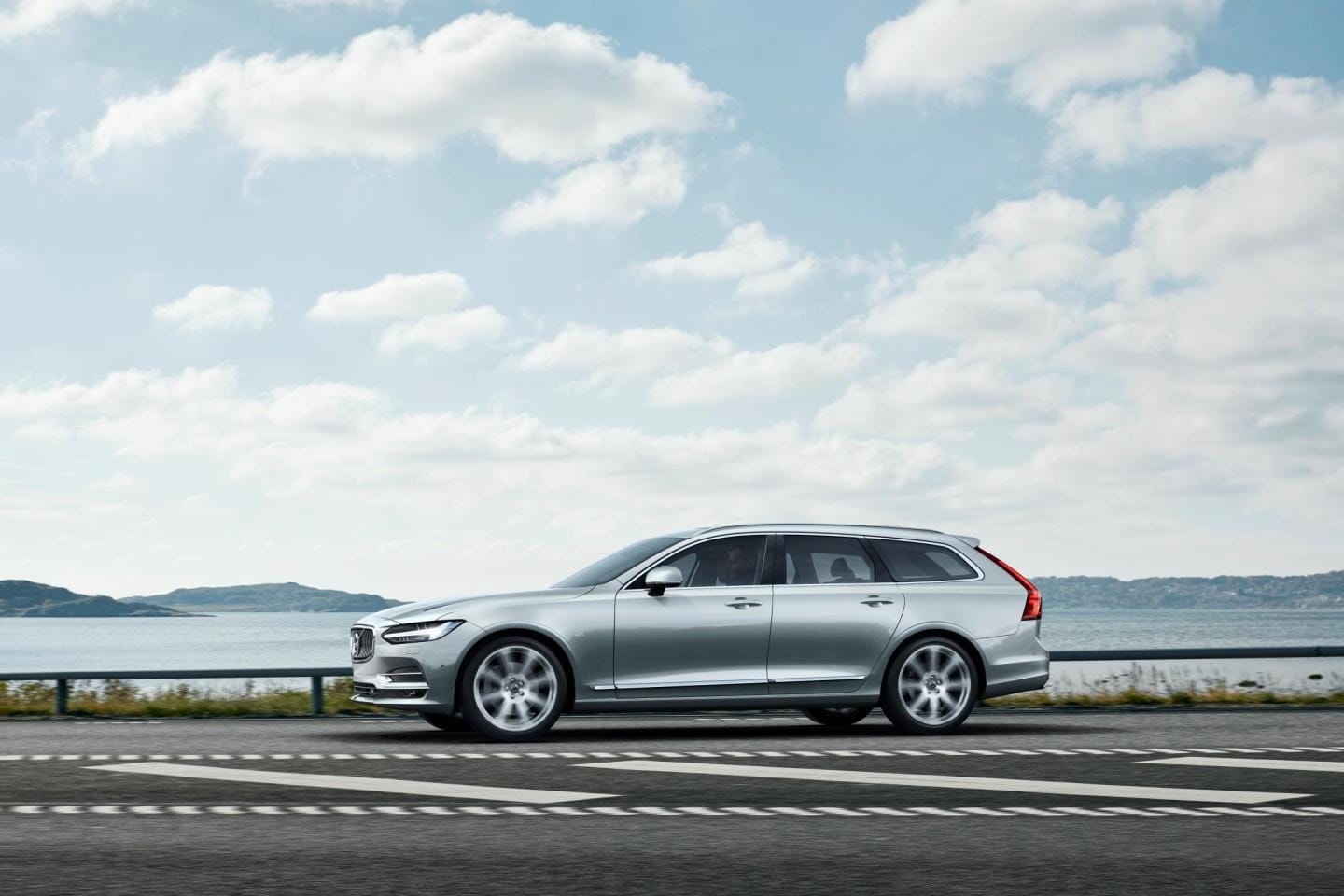 Perfil lateral del Volvo V90 cerca del mar, líneas aerodinámicas.