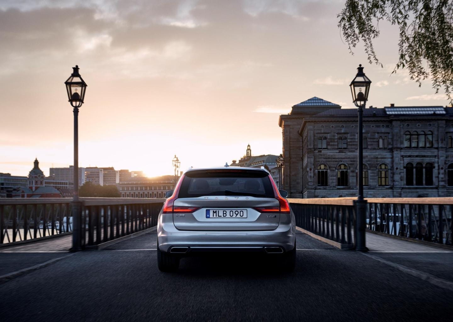 Imagen de la trasera del Volvo V90 al atardecer que resalta su diseño iluminado.
