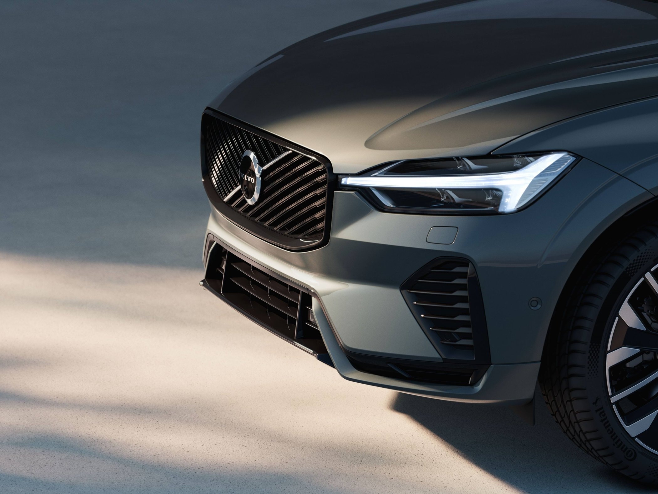 Primer plano de la parrilla del Volvo XC60 Híbrido, destacando su frontal moderno.