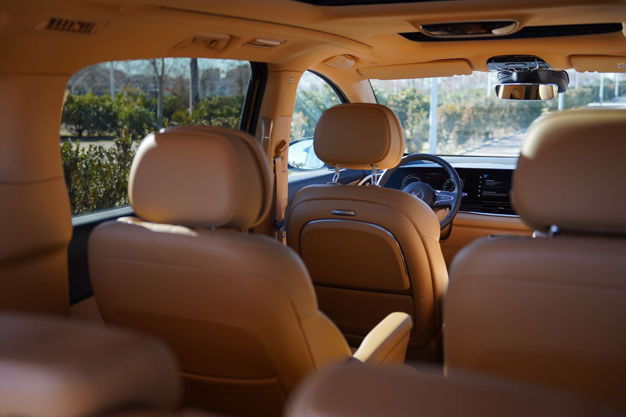 Vista trasera del interior, con asientos en cuero claro y un diseño elegante.