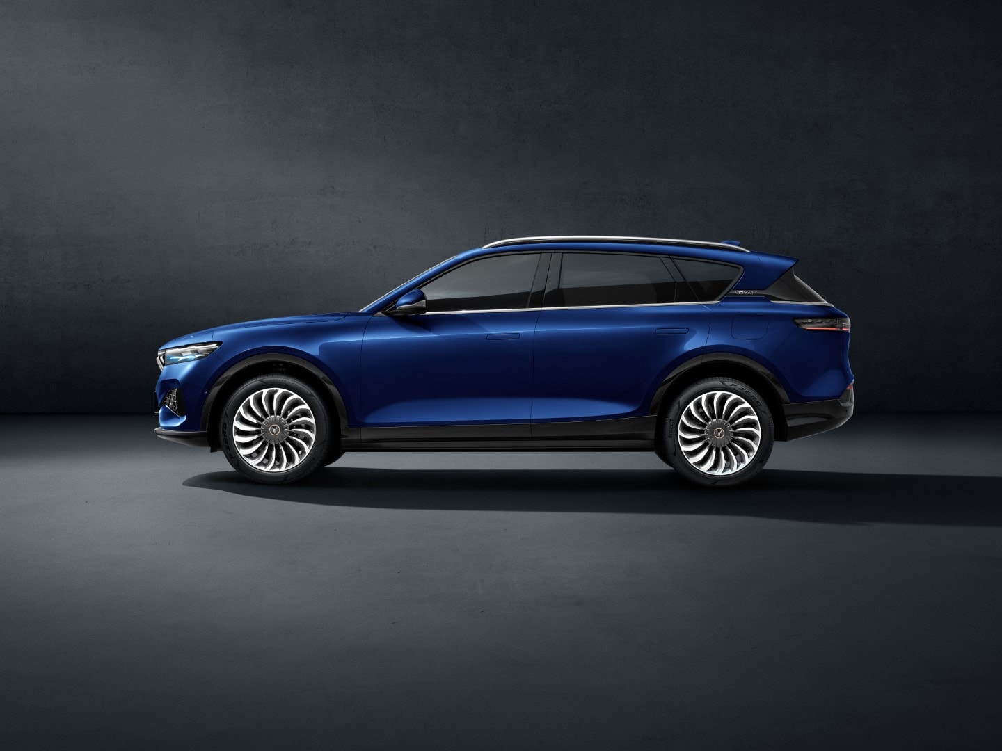 El VOYAH Free azul sobre un pavimento histórico, bajo un impresionante entorno.